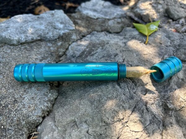 The Joint Jockey River Tripper in Cobalt Blue sitting on rocks with a the top unscrewed exposing a joint inside