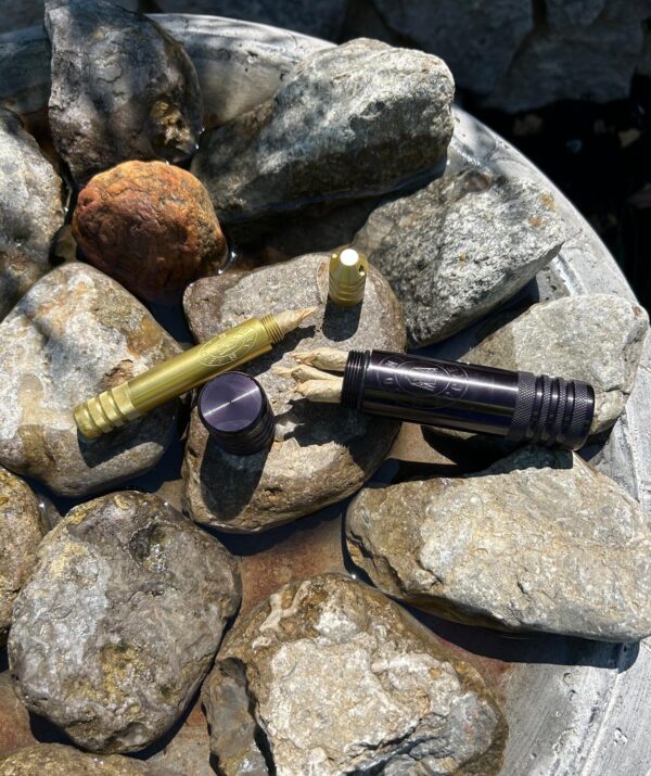 A Joint Jockey Day Tripper and River Tripper sit among wet rocks while their contents are dry. The River Tripper holds one joint, while the Day Tripper holds three joints. The Day Tripper is in Outer Space Black and the River Tripper is in Goldenrod Gold